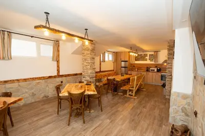 a kitchen and dining room with wooden tables and chairs at Къща за гости Оскови in Velingrad