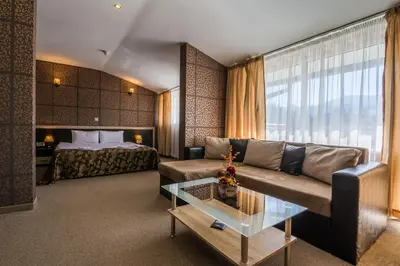 a hotel room with a couch and a bed at Hotel Royal Borovets in Borovets