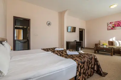 a hotel room with a large bed and a couch at Hotel Royal Borovets in Borovets