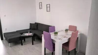 a living room with a couch and a table and chairs at Tea House Samokov in Samokov