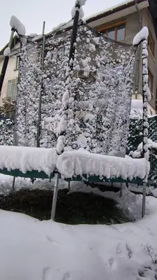 a bench covered in snow in front of a building at Tea House Samokov in Samokov