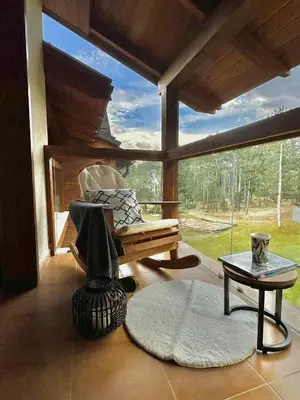 a living room with a chair and a table at Spacious penthouse chalet apartment in Pirin Golf and Country Club in Razlog