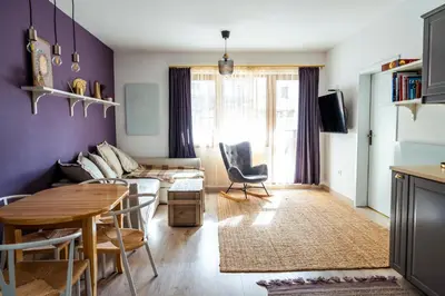 a living room with a couch and a table at Large Stylish 2-bedroom apt near ski road, 5 min to Gondola & Bar Street in Bansko
