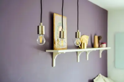 a shelf with three lights on a purple wall at Large Stylish 2-bedroom apt near ski road, 5 min to Gondola & Bar Street in Bansko