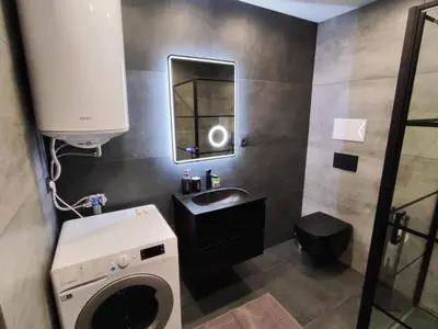 a bathroom with a sink and a washing machine at View apartment #2 in Bansko