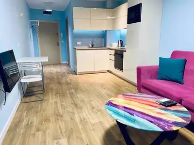 a living room with a pink couch and a table at Modern Turquoise Apartment/free WiFi in Sofia