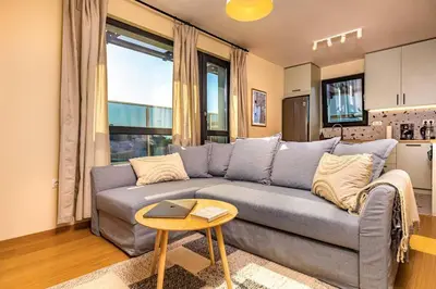 a living room with a gray couch and a table at Hills View Central Apartment in Plovdiv