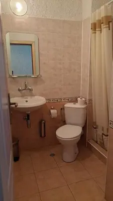 a small bathroom with a toilet and a sink at REAL Guest House in Bansko