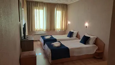 a hotel room with two beds and a television at REAL Guest House in Bansko