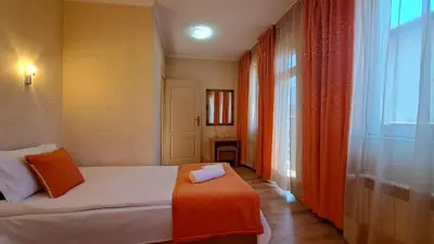 a hotel room with a bed with an orange blanket at REAL Guest House in Bansko