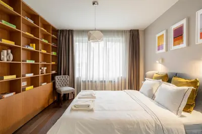 a bedroom with a large bed and a chair at NEW High-End Designer 3BR Central Apt Free Parking in Sofia