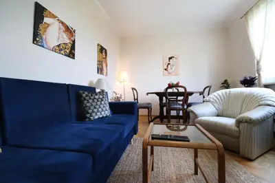 a living room with a blue couch and a table at Spacious and Central Vintage - Modern Apartment in Sofia