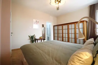 a bedroom with a large bed with a wooden headboard at Spacious and Central Vintage - Modern Apartment in Sofia