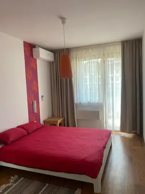 a bedroom with a red bed and a window at Neon Gondola apartment in Bansko
