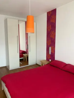 a bedroom with a red bed with a red blanket at Neon Gondola apartment in Bansko