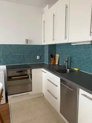 a kitchen with white cabinets and a stainless steel sink at Neon Gondola apartment in Bansko
