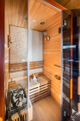 a sauna with wood paneling and a glass wall at Vila Toplika in Kara Agach