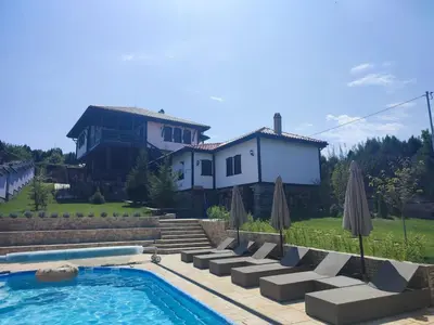 a house with a swimming pool with chairs and umbrellas at Vila Toplika in Kara Agach