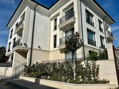 a large white building with balconies and flowers at ARHEYA 3 apart АРХЕЯ 3 апартамент за гости in Karlovo