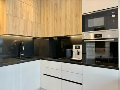 a kitchen with white cabinets and black appliances at City Modern & Classy Apartment for 4 Guests & Parking in Sofia