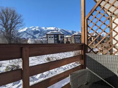 a view of a snowy mountain from a wooden fence at Sapphire Mountain 1 in Bansko