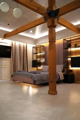 a bedroom with a large bed with a wooden beam at Bansko Nest in Bansko