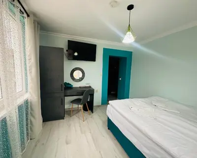 a bedroom with a bed and a desk in it at VELI HOUSE VELINGRAD/ ВелиХаус Къща за гости Велинград in Velingrad