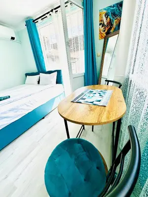 a small room with a table and a bed at VELI HOUSE VELINGRAD/ ВелиХаус Къща за гости Велинград in Velingrad
