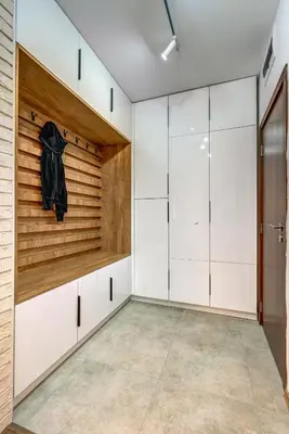 a walk in closet with white cabinets and a wooden wall at N.Joy Holiday Apartment 532 by Oak Residence in Smolyan