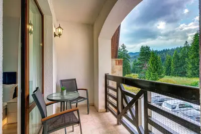 a balcony with a table and chairs and a view at N.Joy Holiday Apartment 532 by Oak Residence in Smolyan