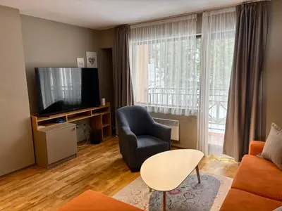 a living room with a couch and a chair and a television at N.Joy Holiday Apartment 413 by Sunny Hills in Pamporovo