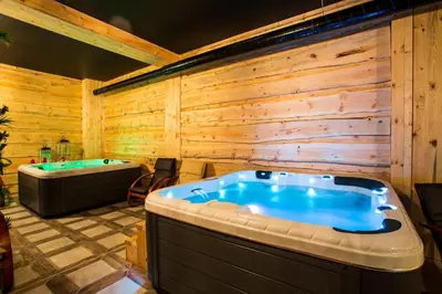 a jacuzzi tub in a room with wooden walls at N.Joy Holiday Apartment 413 by Sunny Hills in Pamporovo