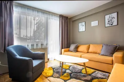 a living room with a couch and a chair at N.Joy Holiday Apartment 413 by Sunny Hills in Pamporovo
