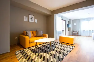 a living room with a yellow couch and a table at N.Joy Holiday Apartment 417 by Sunny Hills in Pamporovo