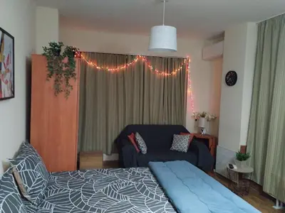 a bedroom with a bed and a couch and lights at Predela 1 - Studio 04 near Bansko Ski Lift in Bansko