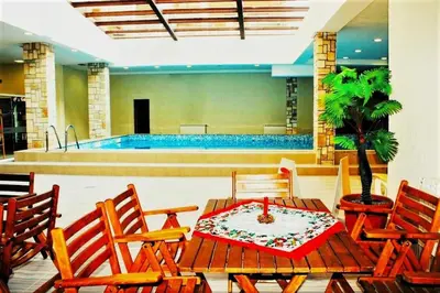 a room with a table and chairs and a pool at Predela 1 - Studio 04 near Bansko Ski Lift in Bansko