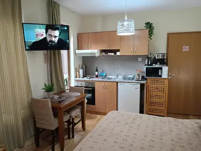 a kitchen with a table and a tv on the wall at Predela 1 - Studio 04 near Bansko Ski Lift in Bansko