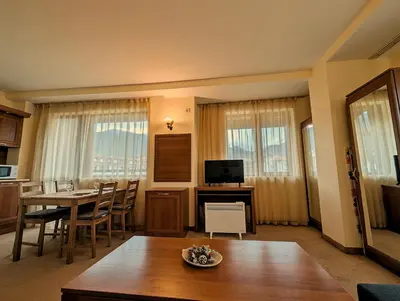 a living room with a table and a dining room at Great View Apartment near Gondola in Bansko