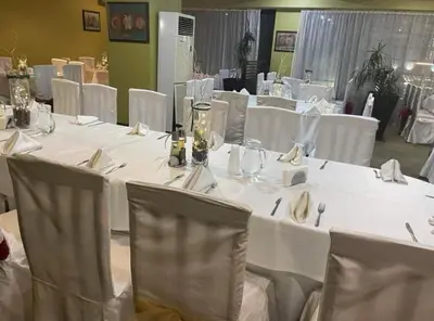 a group of tables with white table cloths and chairs at Private Apartments in Hotel Snezhanka in Pamporovo