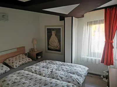a bedroom with two beds and a painting on the wall at Private Apartments in Hotel Snezhanka in Pamporovo