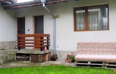 a house with a bench and a fireplace in the yard at Deers in Bansko