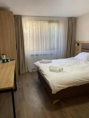 a bedroom with a bed with two towels on it at Deers in Bansko