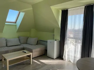 a living room with a couch and a window at ZaraApartHotel in Sofia