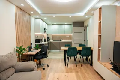 a kitchen and living room with a table and chairs at One-Bedroom apartment with Free Street Parking, Free Gym Pass and Office Setup in Plovdiv