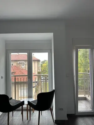 a room with two chairs and a table and a balcony at Бутик хотел ресторант брасери и релакс зона Сажитариус in Kyustendil