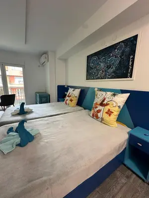 a bedroom with two beds and a painting on the wall at Бутик хотел ресторант брасери и релакс зона Сажитариус in Kyustendil