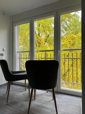 a room with two chairs and two windows at Бутик хотел ресторант брасери и релакс зона Сажитариус in Kyustendil