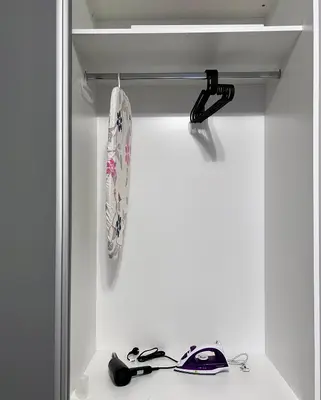 a white closet with a shelf and a pair of shoes at Harmony apartment in Sofia