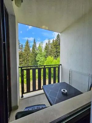 a balcony with a table and a view of trees at Forest View Studio D25 in Borovets