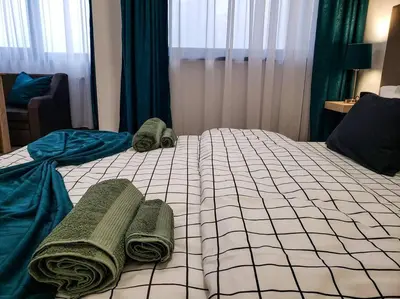 a bedroom with a bed with green towels on it at Forest View Studio D25 in Borovets